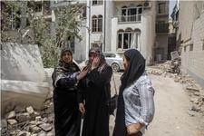 A woman in Tehran, being comforted by two others while crying near her home, which was hit by an Israeli airstrike
