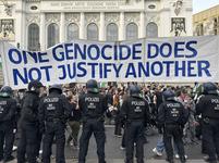 Officers in black and white POLIZEI uniforms face a crowd of pro-Palestinians demonstrators