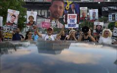 Protestors hold up photos of loved ones and signs calling for an immediate hostage release deal
