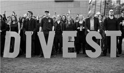 People hold up large letters to spell DIVEST