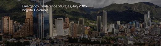 A landscape photo of Bogota, Colombia showing a cluster of city buildings and green mountains in the background