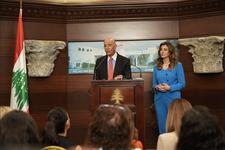 Tom Barrack and Morgan Ortagus, the deputy special envoy to the Middle East, hold a press conference. Barrack is speaking at the lectern wearing a black suit with light blue dress shirt and red tie. Ortagus is standing by wearing a bright blue pantsuit.