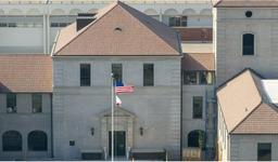 The outside of a high school in Beverly Hills. The American flag and State of California flag fly on a pole in front of the school.