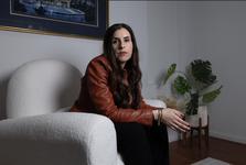 Randa Abdel-Fattah at home seated on a white loveseat
