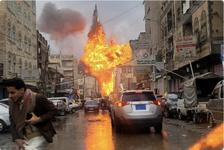 A fireball rises from the site of an Israeli air strike. The city street is crowded with cars and a person is seen running away from the blast.