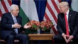 Trump with Palestinian President Mahmoud Abbas. Both are sitting in leather arm chairs on either side of an accent table with a floral arrangement. Flags of the US and Palestine stand in a row behind them.