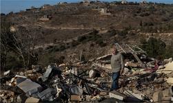 Abdul Aziz Chreim walks over the rubble left of his destroyed home