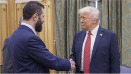 US President Donald Trump (right) shakes hands with Syria's Ahmed al-Sharaa. They are both wearing navy blue suits.
