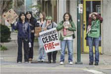 Girls stand on a street corner holding signs calling for a ceasefire and freedom for Palestine