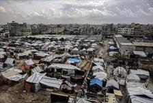 Tents are clustered together surrounded by damaged buildings