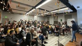 People are seated indoors as they gather for a watch-party