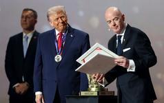 Gianni Infantino, president of FIFA, presents the FIFA Peace Prize to President Donald Trump as Trump grins wearing a medal around his neck.